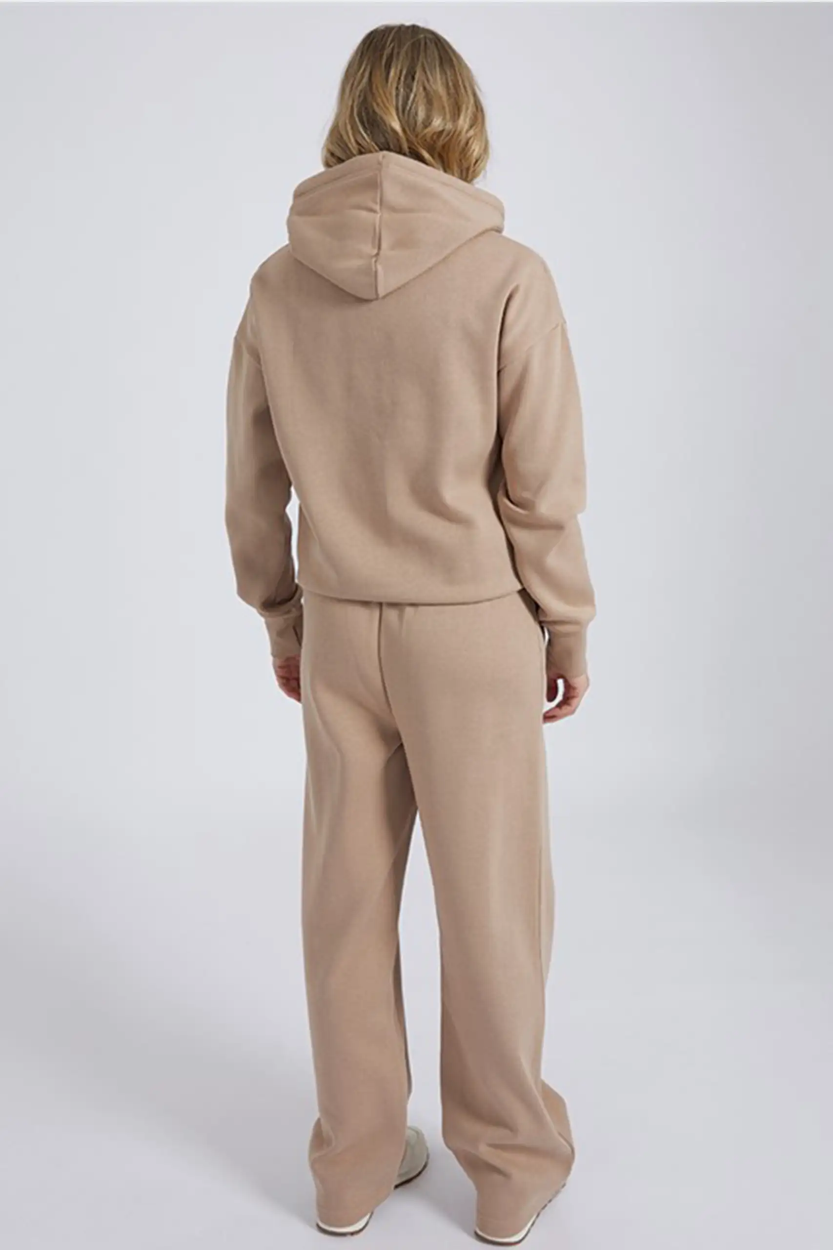 Women wearing cotton blend tracksuit with hoodie and wide leg joggers in loose shoulder casual style