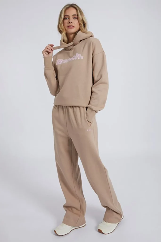 Women wearing cotton blend tracksuit with hoodie and wide leg joggers in loose shoulder casual style